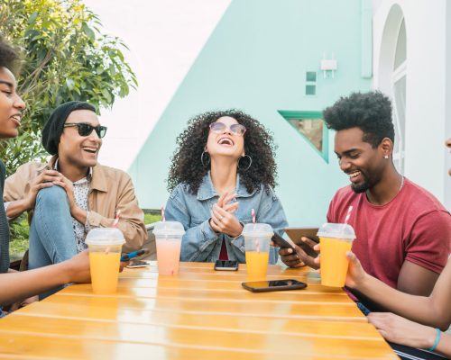 Portrait of Afro friends having fun together and enjoying good time while drinking fresh fruit juice.